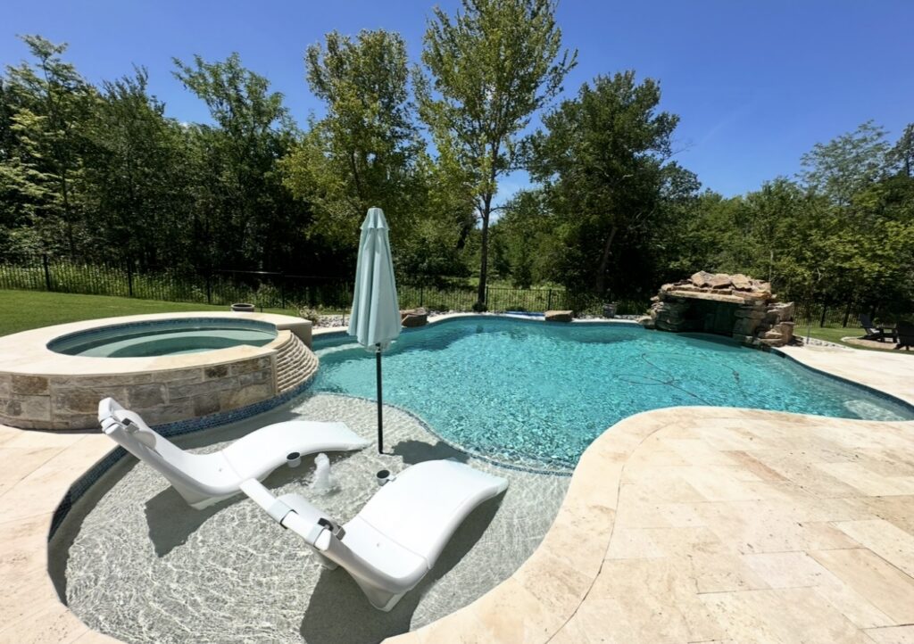Backyard swimming pool with attached round spa and clear maintained water