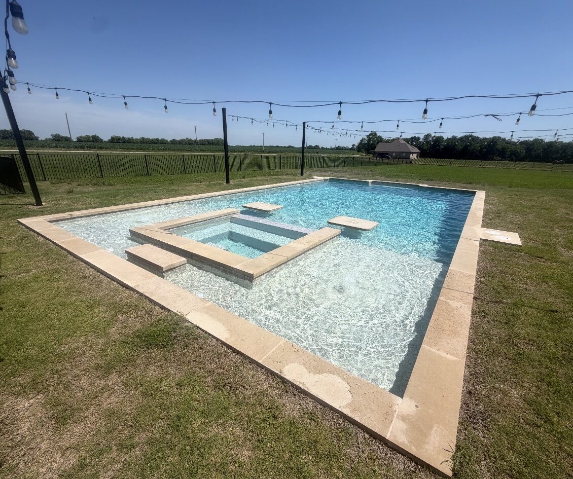 Clean modern swimming pool with tanning ledge, steps, and built in seating