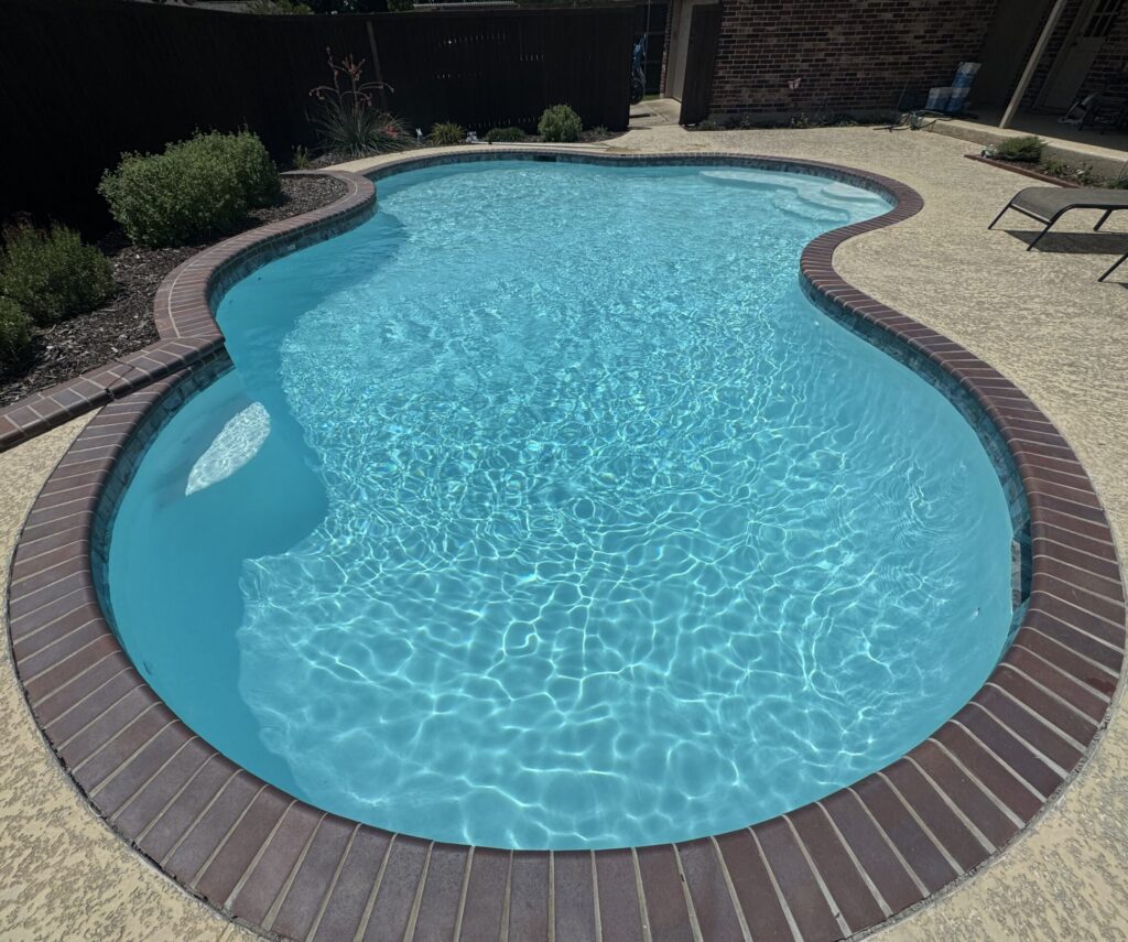Clean residential swimming pool maintained by Spades Pools in the Garland, TX area