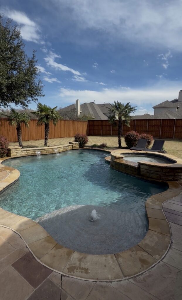 Residential swimming pool with attached spa, fountains, and clear maintained water